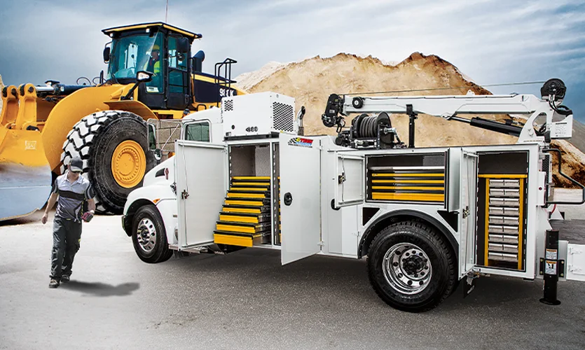 Large White Service Truck with Yellow Drawers and Front End Loader in the Background